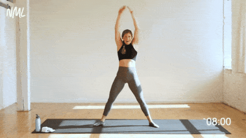 woman performing second position plie squats as part of cardio barre class