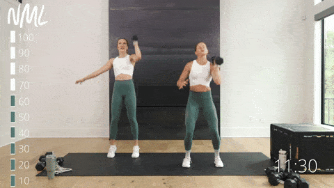 two women performing a single arm push press in an upper body push workout