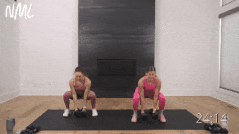 two women performing a squat, curl and shoulder press as example of full body exercises