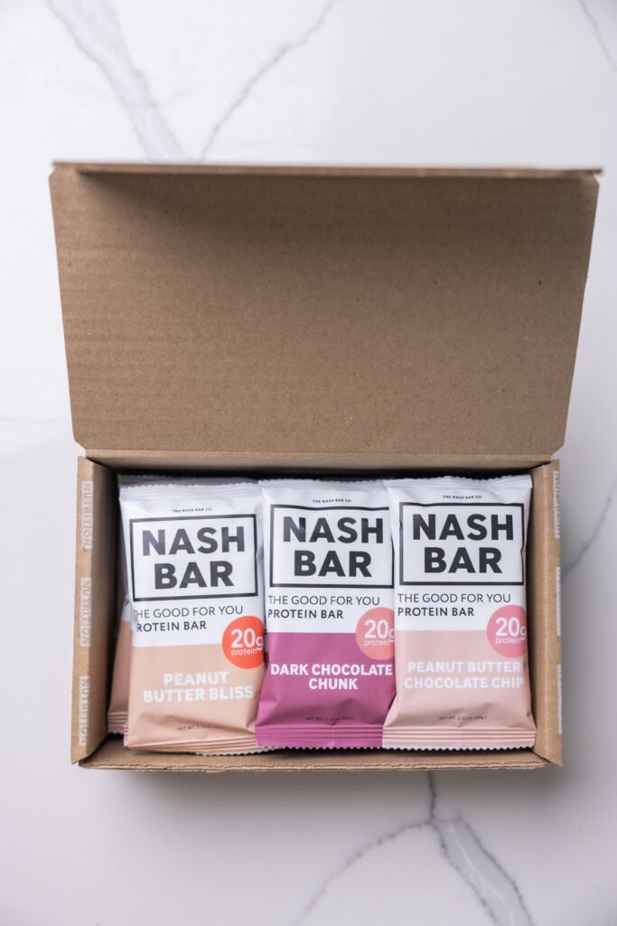 Box of nash protein bars  with flavors peanut butter bliss, dark chocolate chunk and peanut butter chocolate chip. 