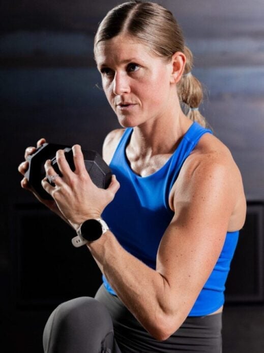 woman performing a standing crunch with a dumbbell in a core workout