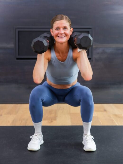 woman performing a squat thruster in a full body workout