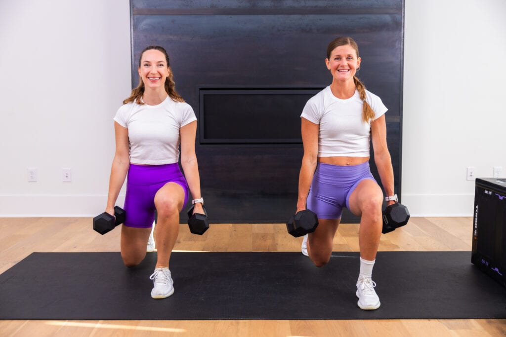 two women performing dumbbell lunges in a leg workout