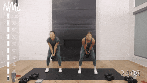two women performing kettlebell swings as part of metcon workout