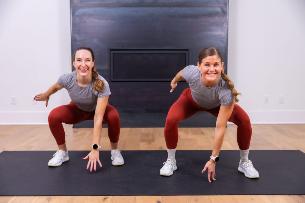 two women performing a squat as part of 15 minute hiit workout