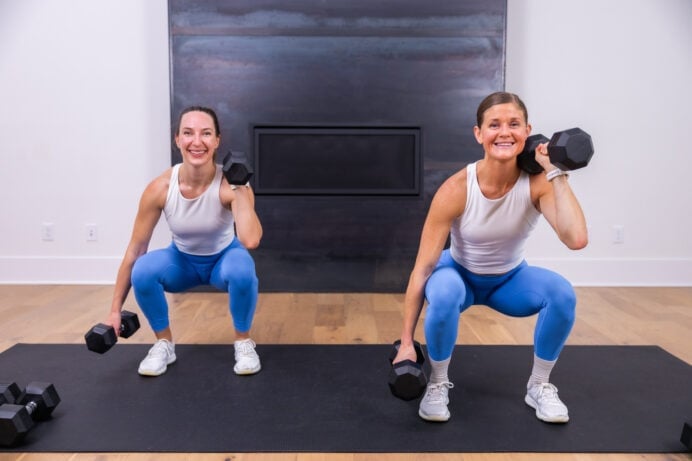 two women performing an uneven rack squat as part of best leg exercises at home tutorial