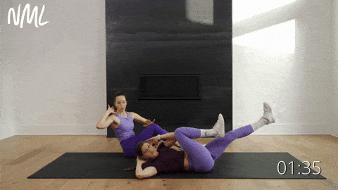two women performing bicycle crunches in an ab workout
