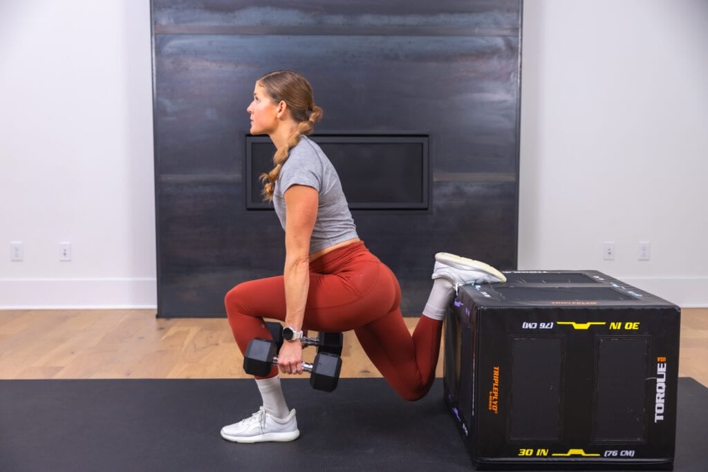 woman performing a rear foot elevated split squat in a glute workout