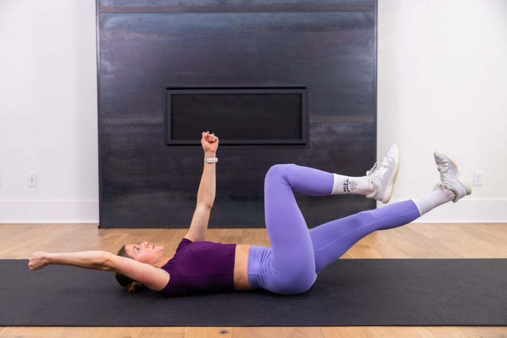 woman performing a bodyweight dead bug in a lower ab workout