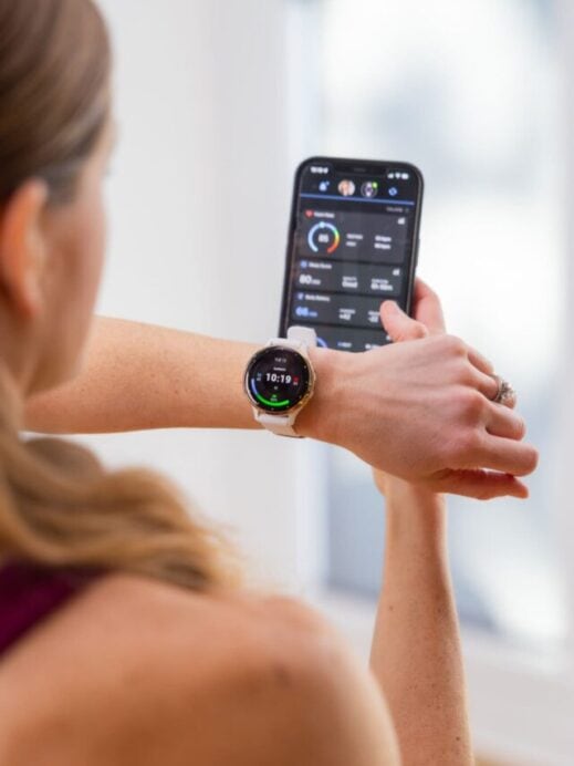 woman wearing the garmin watch and looking at the connect app on her phone