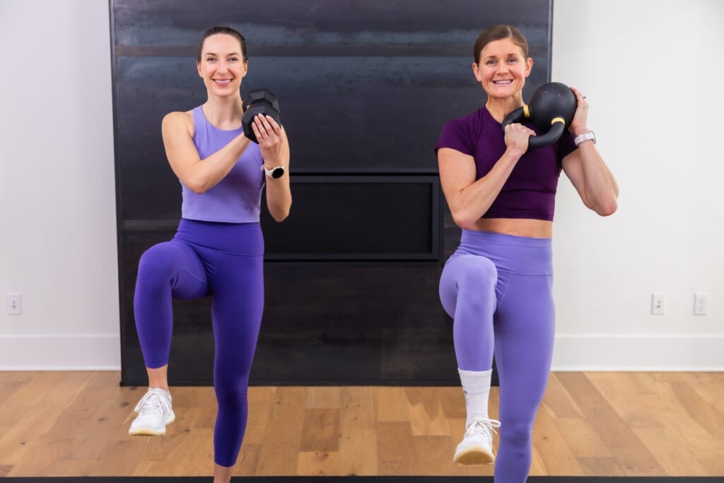 two women performing a kettlebell clean and march