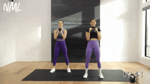 two women performing a goblet squat with a kettlebell