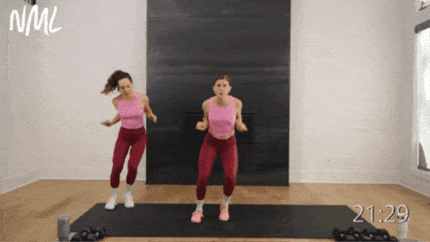 two women demonstrating lateral walks with overhead press as part of walking workout