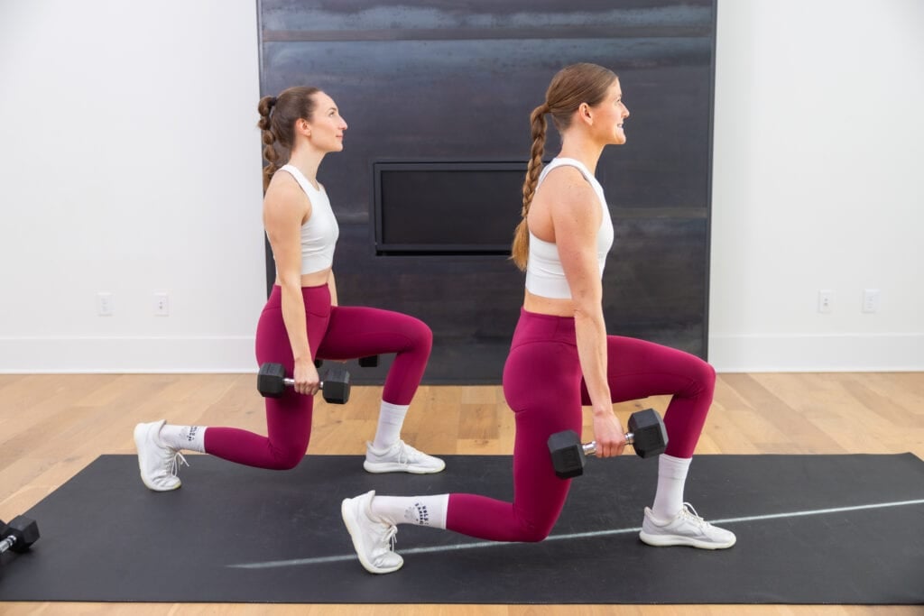 two women performing a dumbbell reverse lunge as example of dumbbell exercises