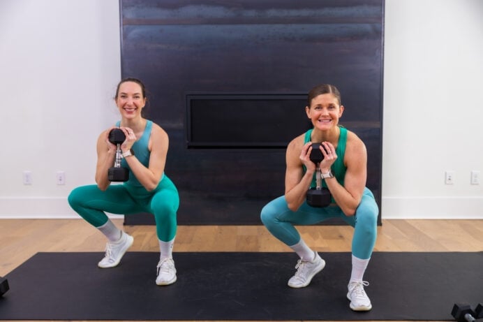 two women performing b stance squats as example of dumbbell leg exercises