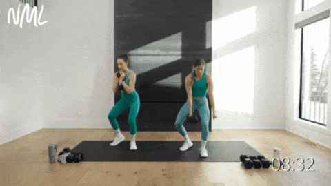 two women performing a squat variation with dumbbells as example of dumbbell leg exercises