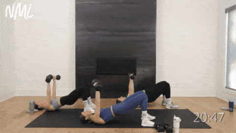 three women performing dumbbell glute bridge hold with a chest press