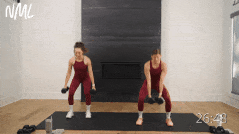 two women performing squats and push ups as part of dumbbell workout routine