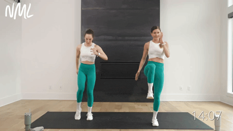 two women performing a pulsing lunge and knee drive in a beginner workout routine