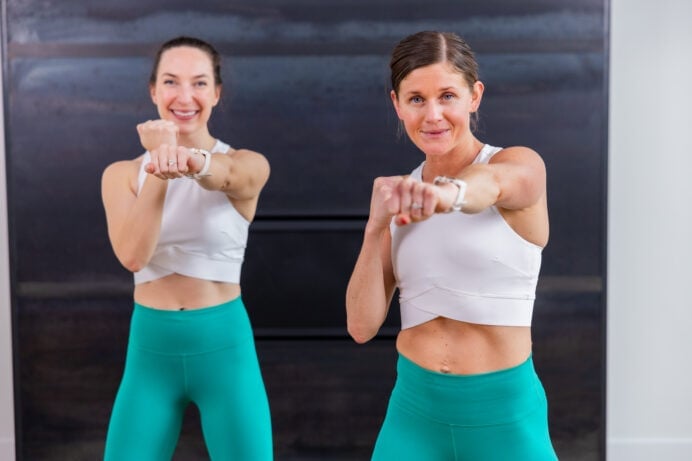 two women performing a front punch in a workout routine for beginners