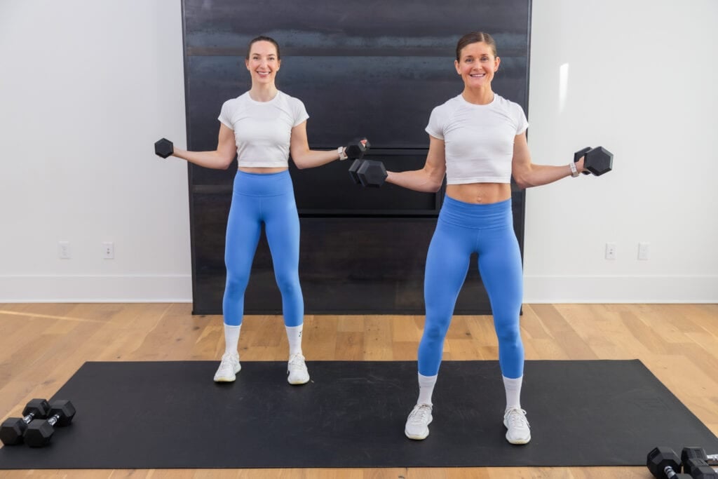 two women holding a wide bicep curl with dumbbells in a dumbbell arm workout at home