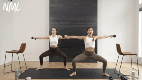 two women performing a second position plie squat as part of pilates barre workout