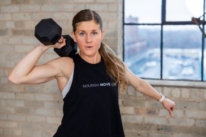 woman performing a single dumbbell exercise as part of single dumbbell workout