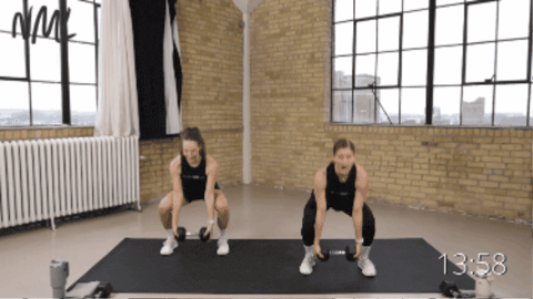 two women performing a compund single dumbbell exercise - a squat, bicep curl, shoulder press and tricep extension
