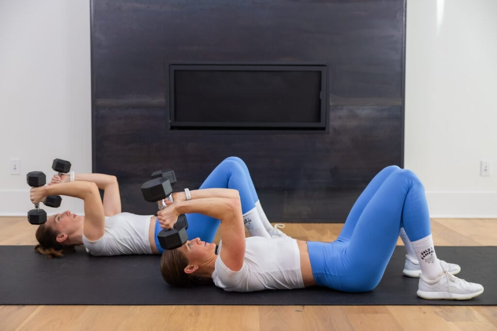 two women performing skull crushers as example of best dumbbell arm exercises