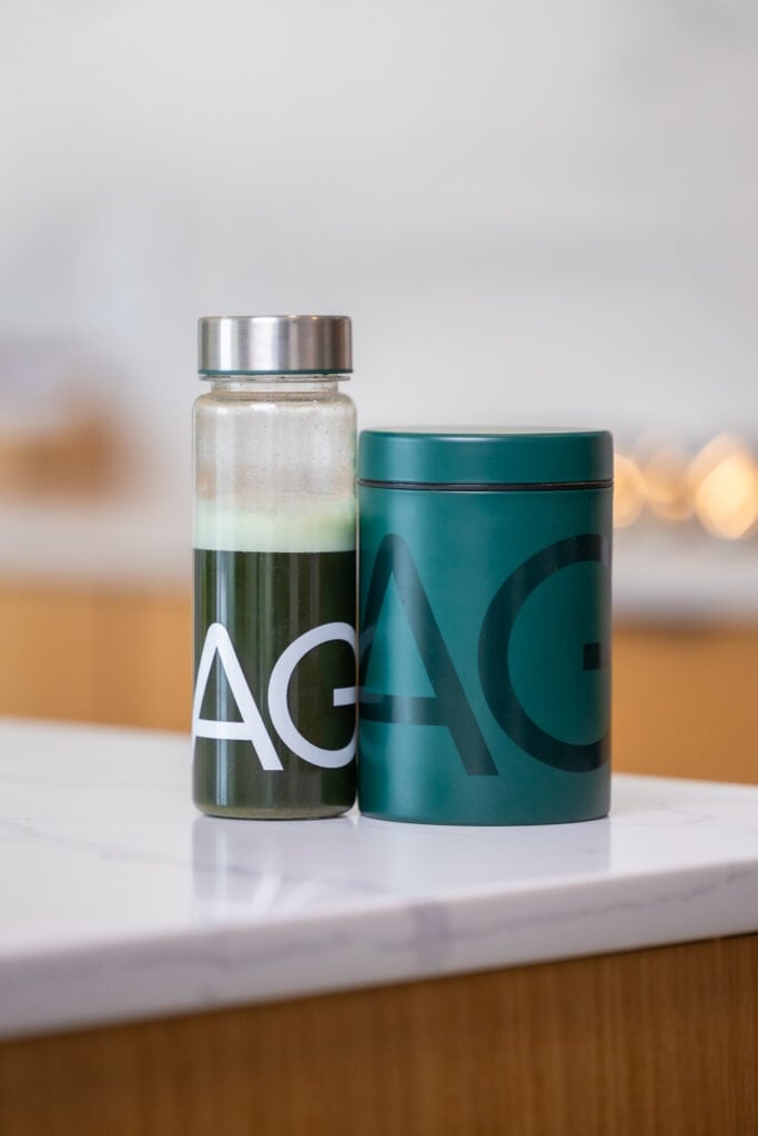 AG1 (athletic greens) with green powders and water bottle full of greens drink. 