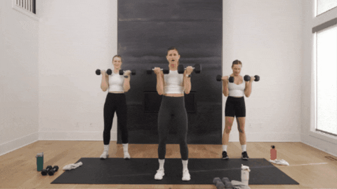 three women performing bicep curls as example of way to get strong arms