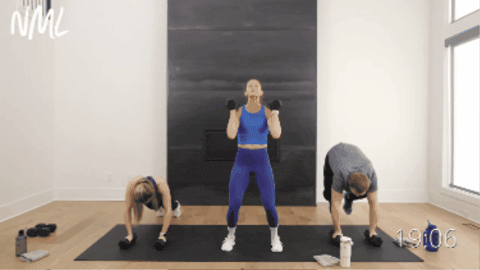 three people performing a dumbbell burpee as part of total body workout