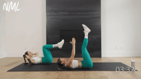 two women performing alternating toe touches as part of upper ab exercises