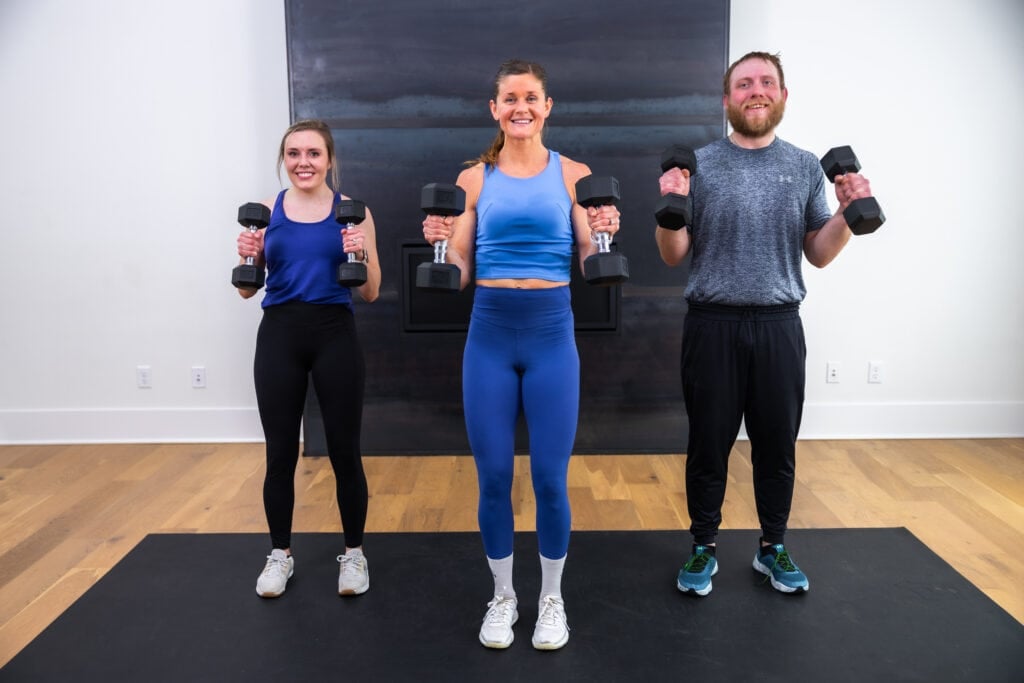 three people performing a dumbbell hammer curl as part of total body workout