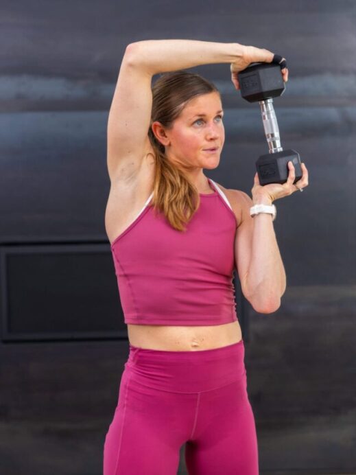 woman performing a dumbbell halo as part of core training with dumbbells