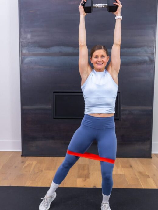woman performing an overhead press as example of LISS cardio exercises