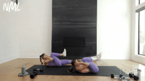 two women performing double crunches as part of core circuit
