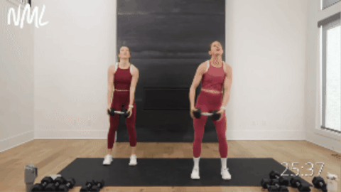 two women performing a dumbbell halo and wood chop as example of core training with dumbbells