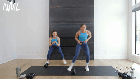 two women performing lateral shuffles and dumbbell pick ups