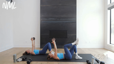 women performing single leg glute bridge skull crushers in a home workout