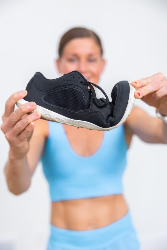 Women showing the bend in a pair of barefoot shoes for women. For people with bad knees.