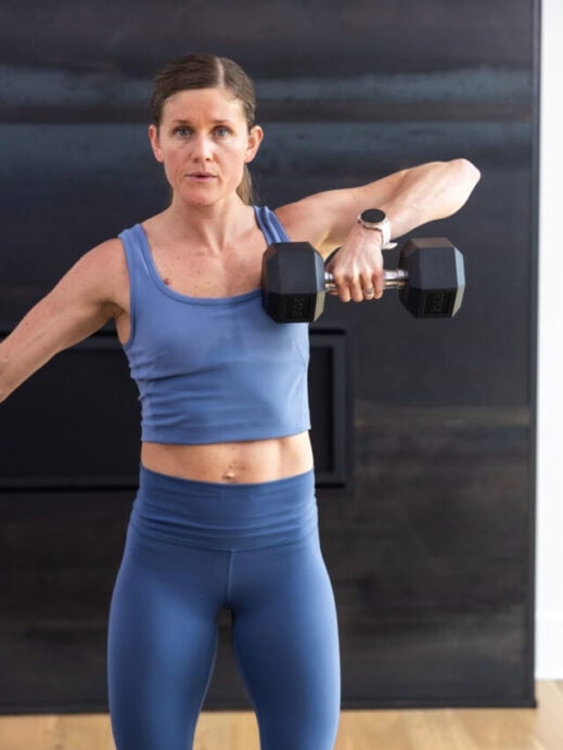 woman performing a single arm upright row in a back and shoulder workout