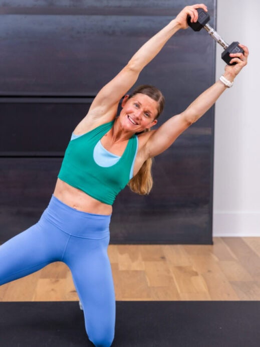 woman performing kneeling oblique crunch as part of barre pilates class