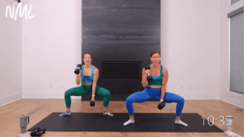 two women performing a plie sequence as part of barre pilates class