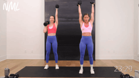 two women performing dumbbell push presses as part of hiit workout routine for women