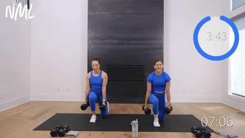 two women performing reverse lunges in a dumbbell full body workout