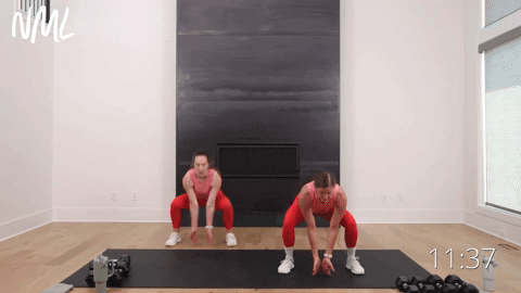 two women performing squat jacks in a full body workout