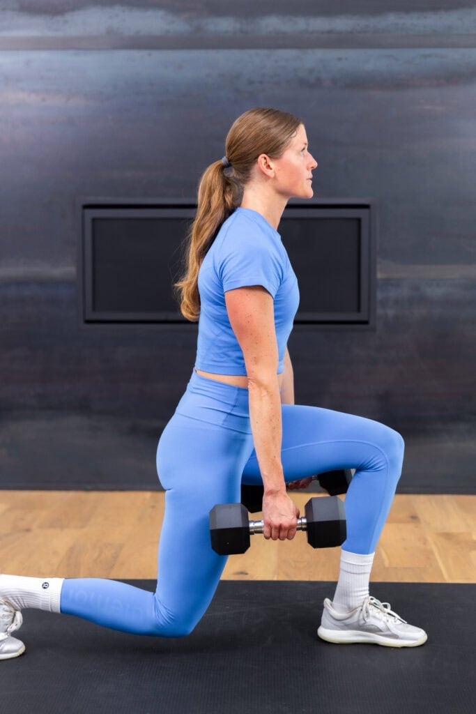 woman performing a reverse lunge in a full body workout