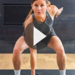 black fireplace with woman standing in front of it performing home workout