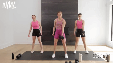 three women performing a Hinge Swing Squat Thruster with one dumbbell in their right hand.